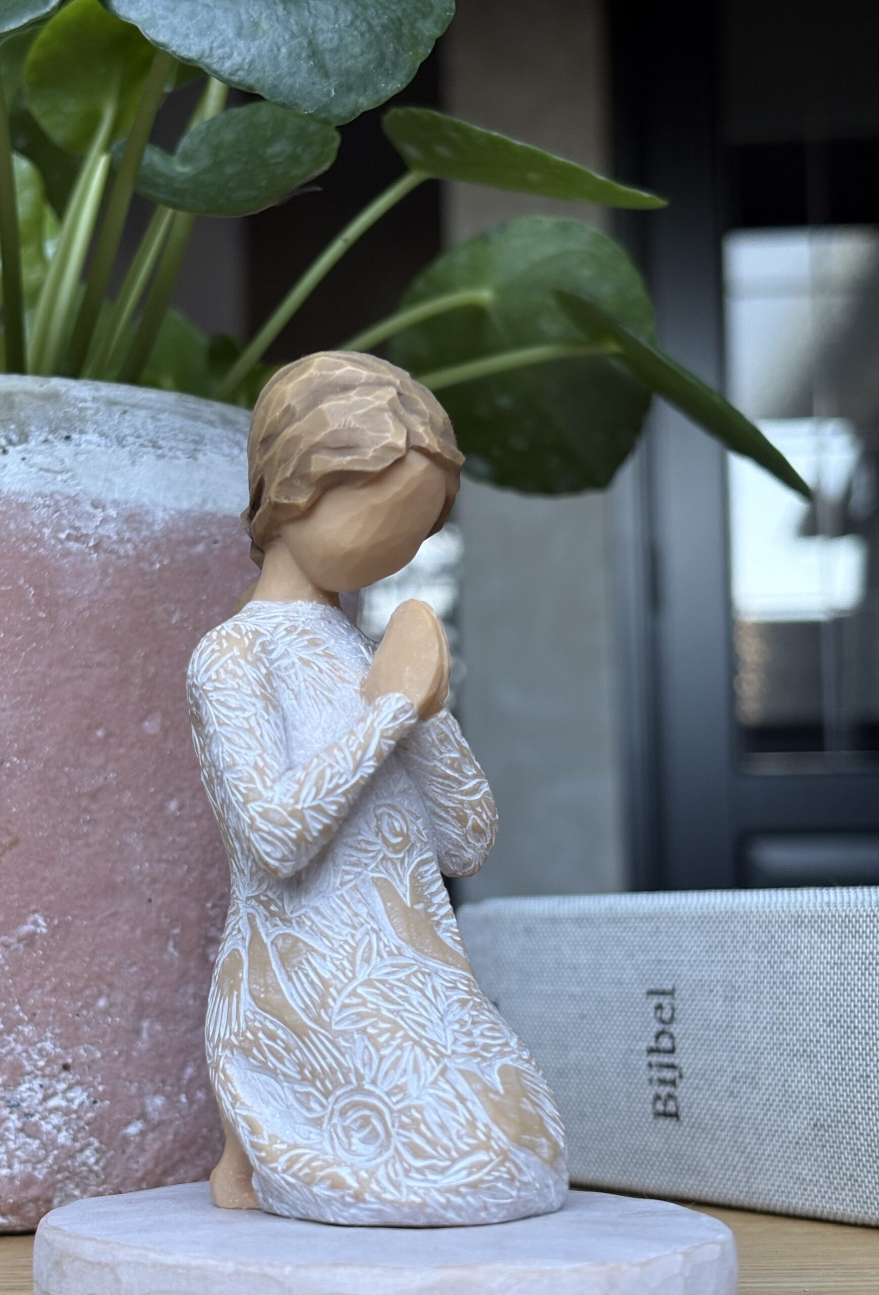Biddende vrouw met de Bijbel als symbool voor geloof en begeleiding